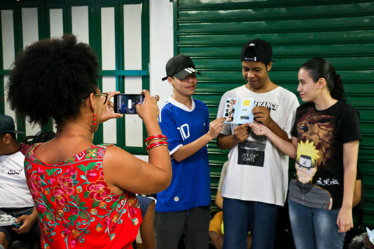 Imagem de adolescentes posando para uma foto com um folder na mas mãos