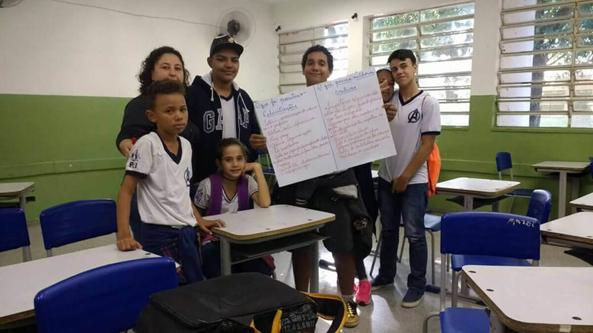 Alunos juntamente com a professora na sala de aula aprensentando trabalho